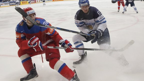 Alexei Yemelin of Russia in action with Aleksander Barkov of Finland