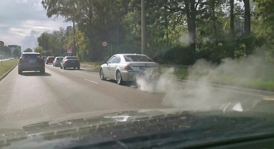 Video: BMW brauc satiksmē ar avārijas gaismām un baltu dūmu mutuli