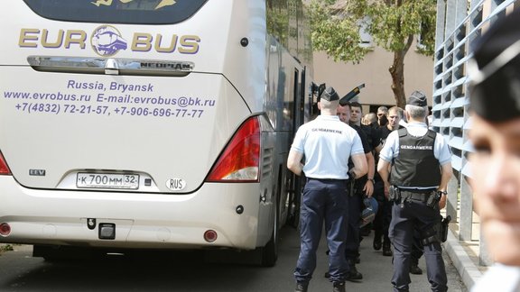 Russian soccer fans are ushered off a bus by gendarmes