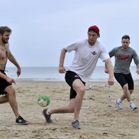 Foto: Rīgas 'Dinamo' hokejisti vingro un spēlē futbolu Jūrmalas smiltīs