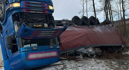 ФОТО, ВИДЕО. Серьезная авария в Латгале: с дороги съехал и перевернулся грузовик с прицепом