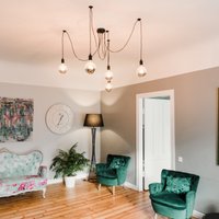 Ar telpaugiem, gleznām un klubkrēsliem dīvāna vietā: stilīgs dzīvoklis Rīgas centrā