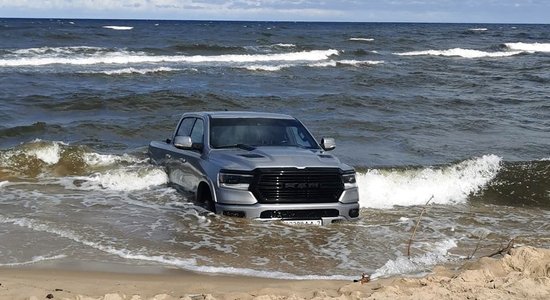 Carnikavas pludmalē jūras viļņi apskauj pamestu pikapu ar Baltkrievijas numuriem