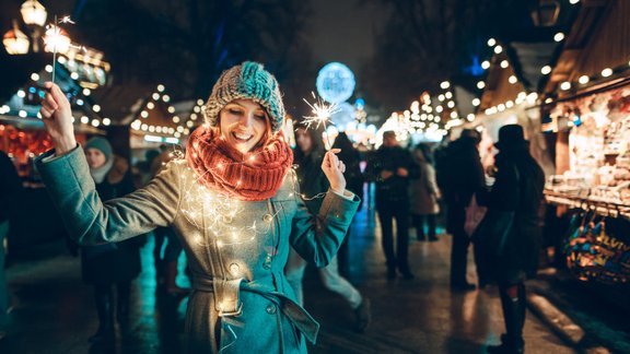 sieviete ziemassvētki brīnumsvecītes tirdziņš lampiņu virtene 