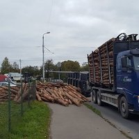 ФОТО: В Пурвциемсе перевернулся лесовоз; бревна упали на одну из машин