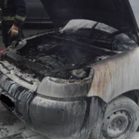 Foto: Rīdzinieki palīdz dzēst aizdegušos auto, bet vadītājs nozūd