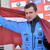 Foto: Martins Dukurs ar Latvijas karogu atkal kāpj uz goda pjedestāla augstākā pakāpiena