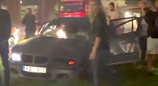 ВИДЕО: BMW на улице Краста перевернулась и снесла столб; пострадали двое